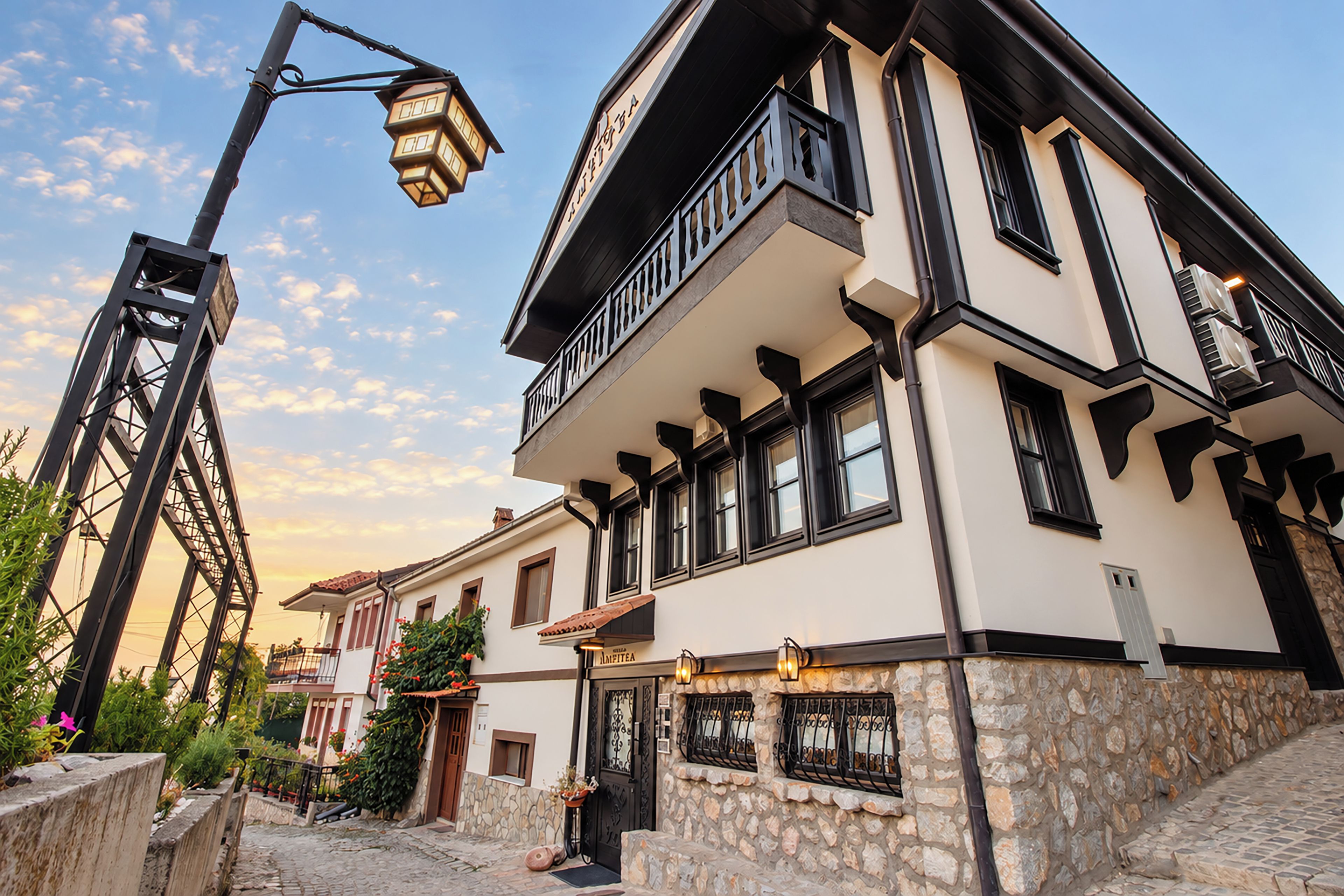 A building with a stone facade, multiple windows, and a balcony.