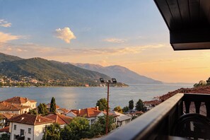 A coastal town with houses, a body of water, and mountains in the background. - Villa Amfitea (Ohrid)