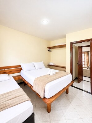 A hotel room with two wooden beds, a wooden bench, a bedside table, and a wardrobe. - Apartment in Taperapua with pool on Rua Arena Axe Moi (Porto Seguro)