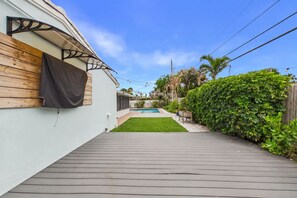 A backyard with a wooden deck, a swimming pool, and a green lawn. - Fantastic 4-bedroom house 1 block from ocean in charming Satellite Beach (Satellite Beach)