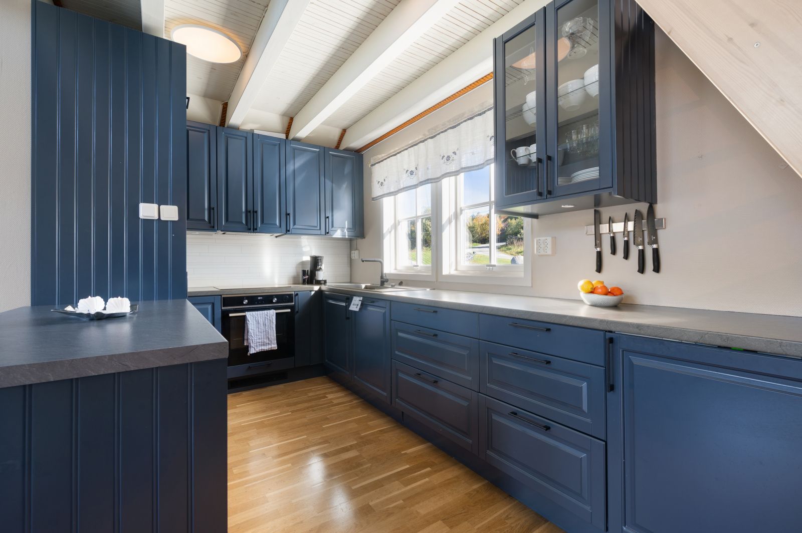 Bright designer kitchen with blue cabinets, big windows, and ample counter space