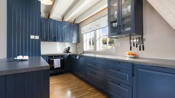 Bright designer kitchen with blue cabinets, big windows, and ample counter space