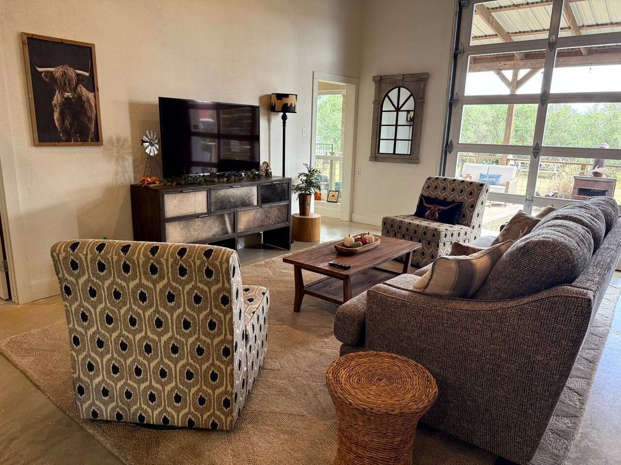 A living room with a sofa, armchair, and a television.