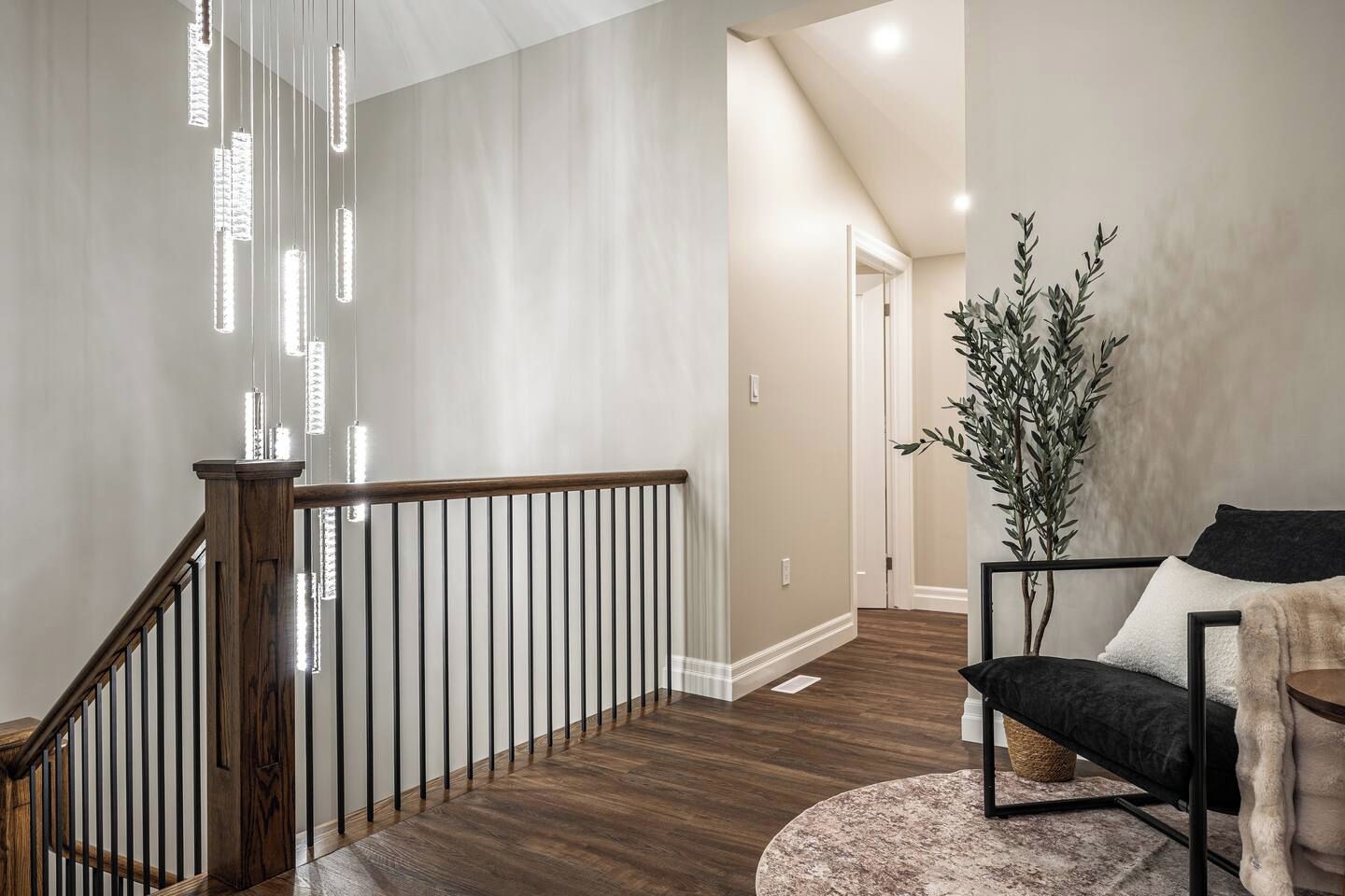 Unwind in a stylish downtown Stratford living room featuring character-rich exposed brick, a comfortable sectional, accent seating, and a TV. Large windows, warm wood tones, and inviting décor create a relaxing space to enjoy after exploring Stratford’s s