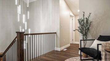 Unwind in a stylish downtown Stratford living room featuring character-rich exposed brick, a comfortable sectional, accent seating, and a TV. Large windows, warm wood tones, and inviting décor create a relaxing space to enjoy after exploring Stratford’s s