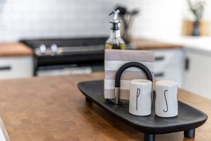 A kitchen counter with a black tray holding two white mugs and a decorative item. - Juno F5: The Curator’s Studio (Stratford)