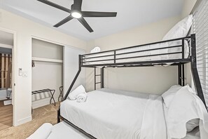 A bunk bed with a ceiling fan, white bedding, and a door leading to a bathroom. - 4BR - Near Stadium - Arcade - Pool Table - Parking (Phoenix)
