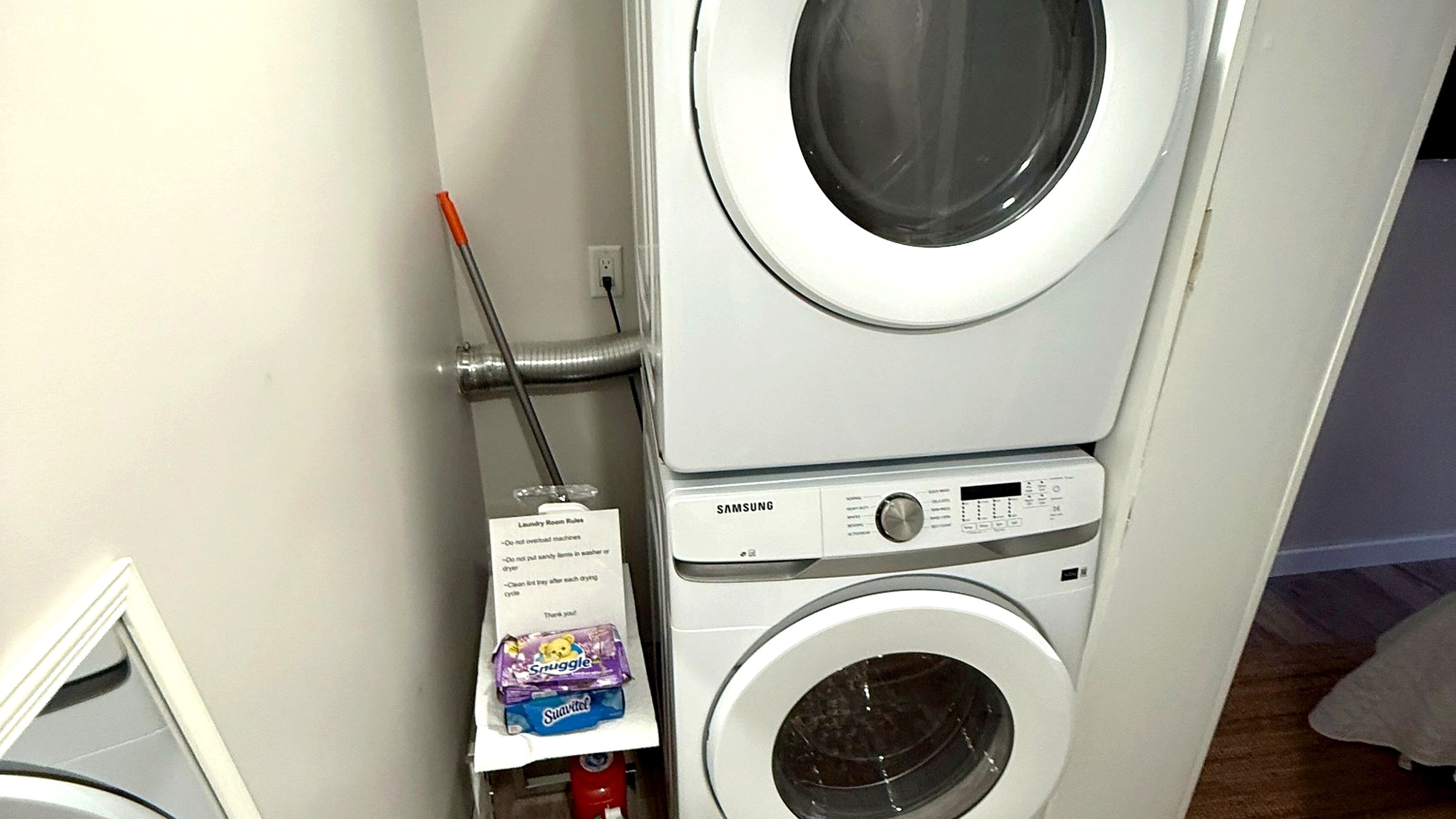 Private laundry room with a stacked washer and dryer.