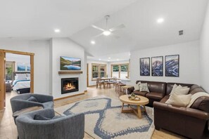 A spacious living room with a fireplace, a sofa, a coffee table, and a television. - Wonderful 3-bedroom house in Silverthorne perfect for your getaway (Silverthorne)