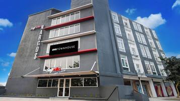 A multi-story building with a prominent sign for 'OYO DOWNHOUSE' and a smaller sign for 'Say hello NARCOS'.