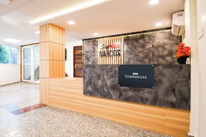 A reception desk with a sign for 'Say Rosario NARCOS' and 'OYO TOWNHOUSE'. - Townhouse Sayhallo Narcos (Bhubaneshwar)