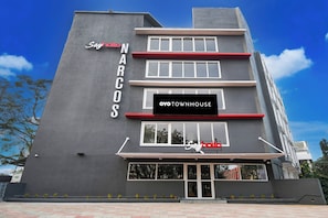 Un edifici amb un cartell que diu 'Narcos' i 'Oyo Townhouse' a la façana.