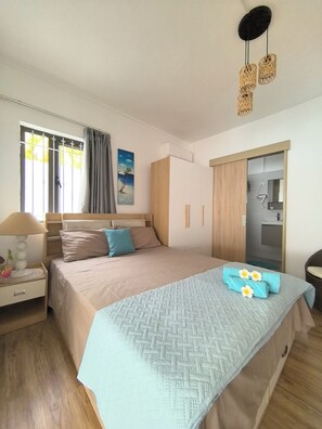 Ein Schlafzimmer mit einem Bett, einem Nachttisch, einer Lampe und einem Bild an der Wand.