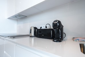 A modern kitchen with a coffee maker, kettle, and toaster on the counter. - Sea Blue Torrox Costa by Casasol (Torrox)
