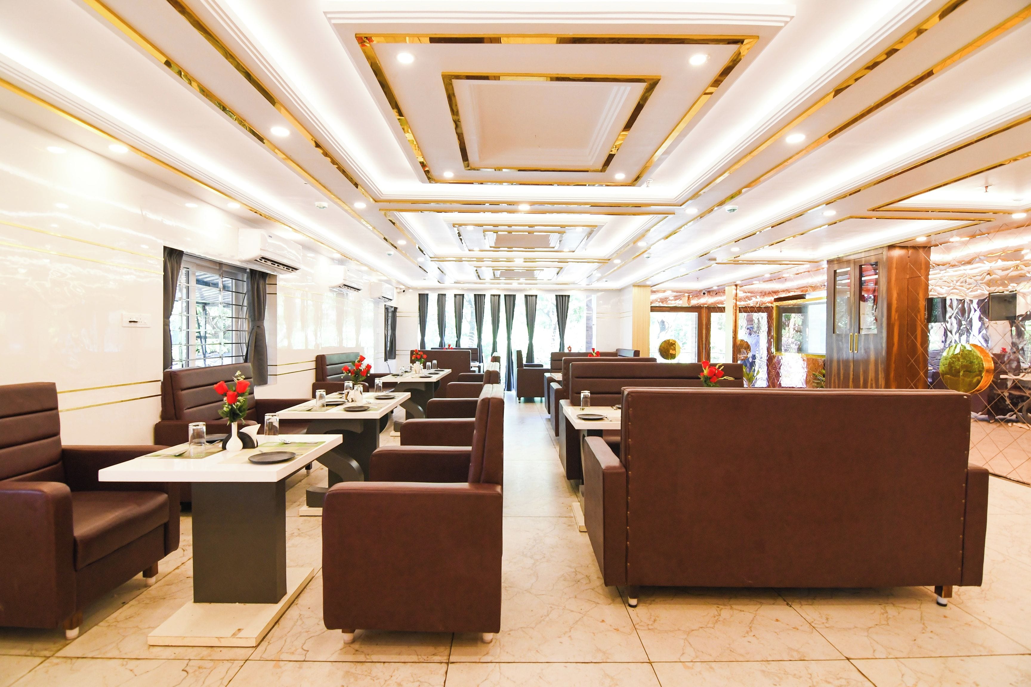 Um restaurante com cabines e mesas, teto com iluminação embutida e chão de azulejos.