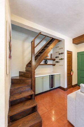 A staircase leading to a kitchen with wine bottles on the wall. - Villa 13 Jarabacoa with AC/ Wifi Jacuzzi (Jarabacoa)
