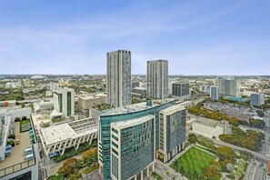 A high-rise urban area with modern buildings, a large open plaza, and a stadium in the distance. - The Metro Miami Retreat, Parking & Amenities (Miami)