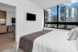 A modern hotel room with a large bed, a flat-screen TV, a city view, and a kitchenette. - The Metro Miami Retreat, Parking & Amenities (Miami)