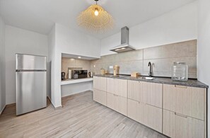 A modern kitchen with a stainless steel refrigerator, a microwave, and a built-in oven. - Casa do Portinho - Country house with a spectacular view of the Atlantic Ocean (Ponta Delgada)
