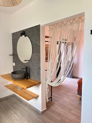 A modern bathroom with a round mirror, a stone sink, and a wooden shelf. - Casa do Portinho - Country house with a spectacular view of the Atlantic Ocean (Ponta Delgada)
