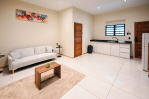 A modern living room with a sofa, a coffee table, and a painting on the wall. - Lure Boutique Hotel (Paramaribo)