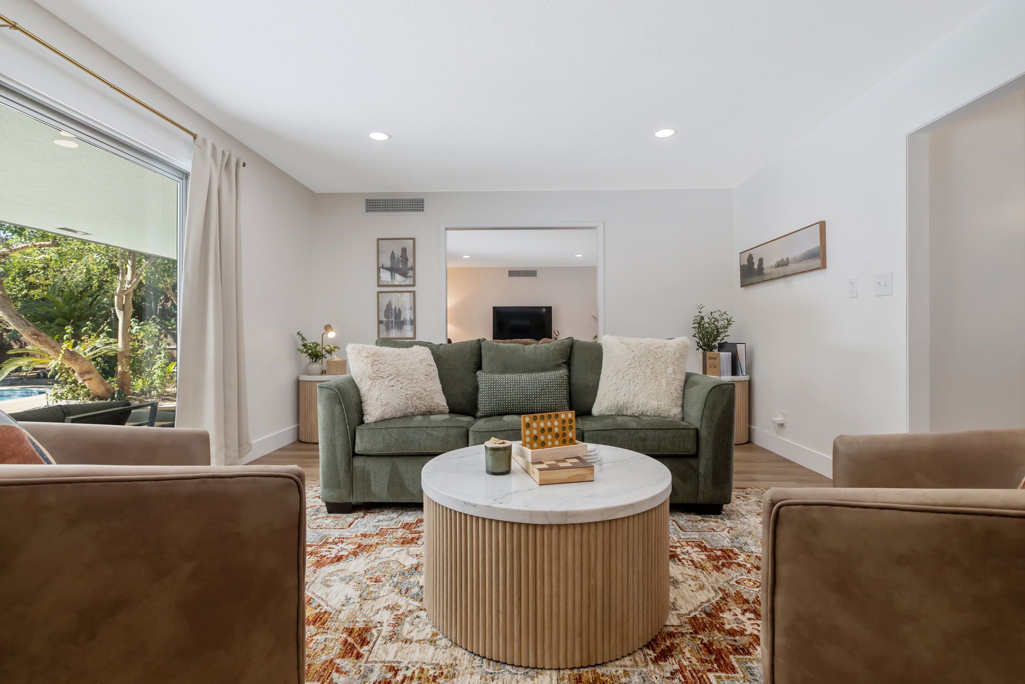A modern living room with a sofa set, a coffee table, and a television in the background.