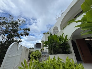 A modern building with a white exterior, a balcony, and a tiled patio area. - Beachfront Villa Gành Dầu 5Brs by Anamoi (Phú Quốc)