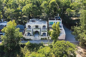 Un bâtiment à deux étages doté d’une cour intérieure, entouré d’une végétation luxuriante.