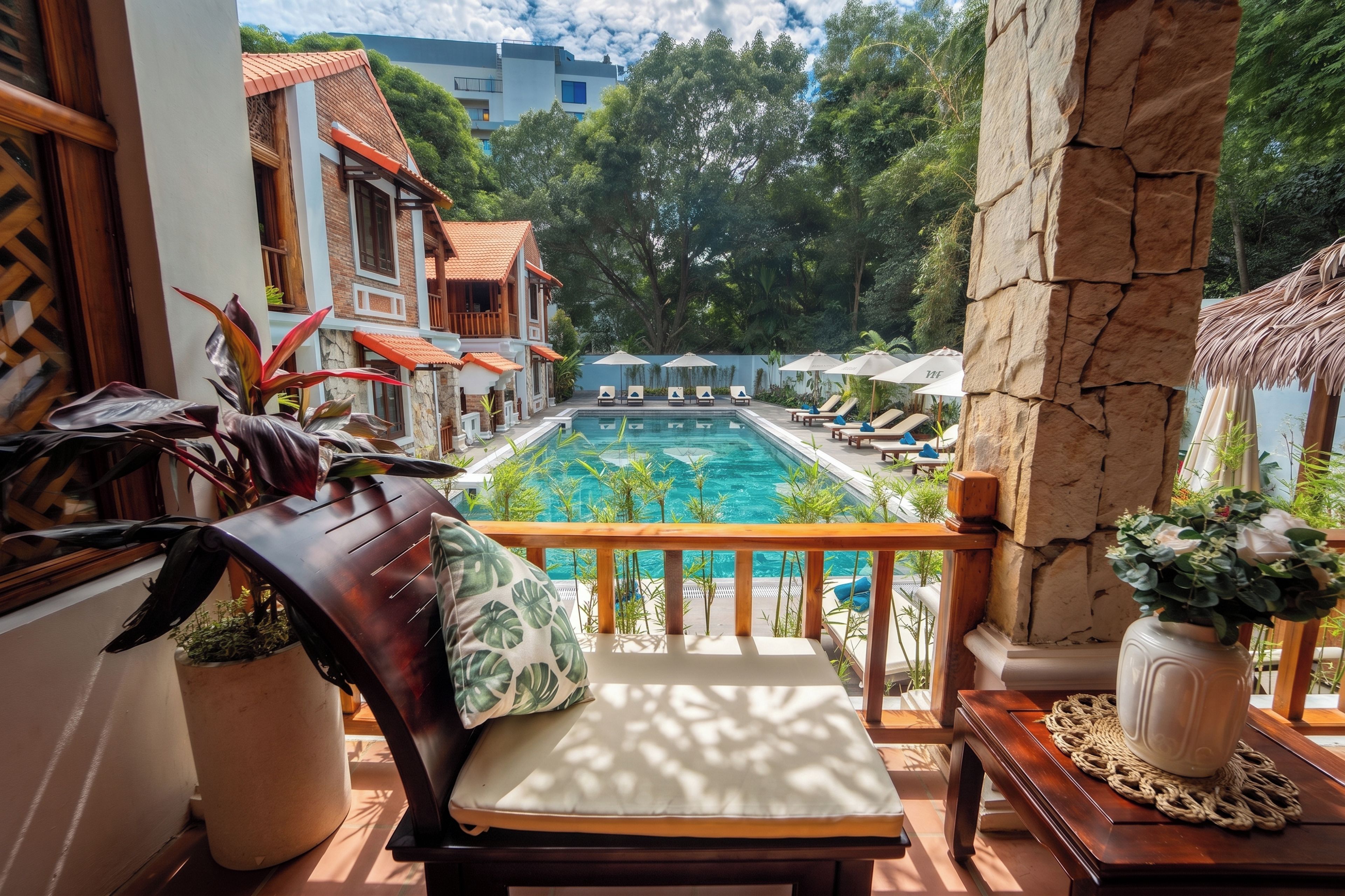 A balcony with a view of a swimming pool, lounge chairs, and potted plants.