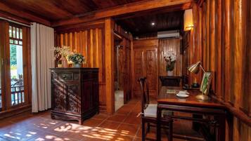 A wooden-paneled room with a dining table, chairs, and a cabinet with decorative items.