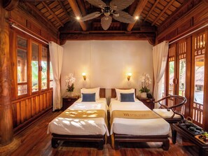 A double room with two beds, wooden walls, a ceiling fan, and a view of the outdoors. - Old Town Boutique Resort (Phu Quoc)