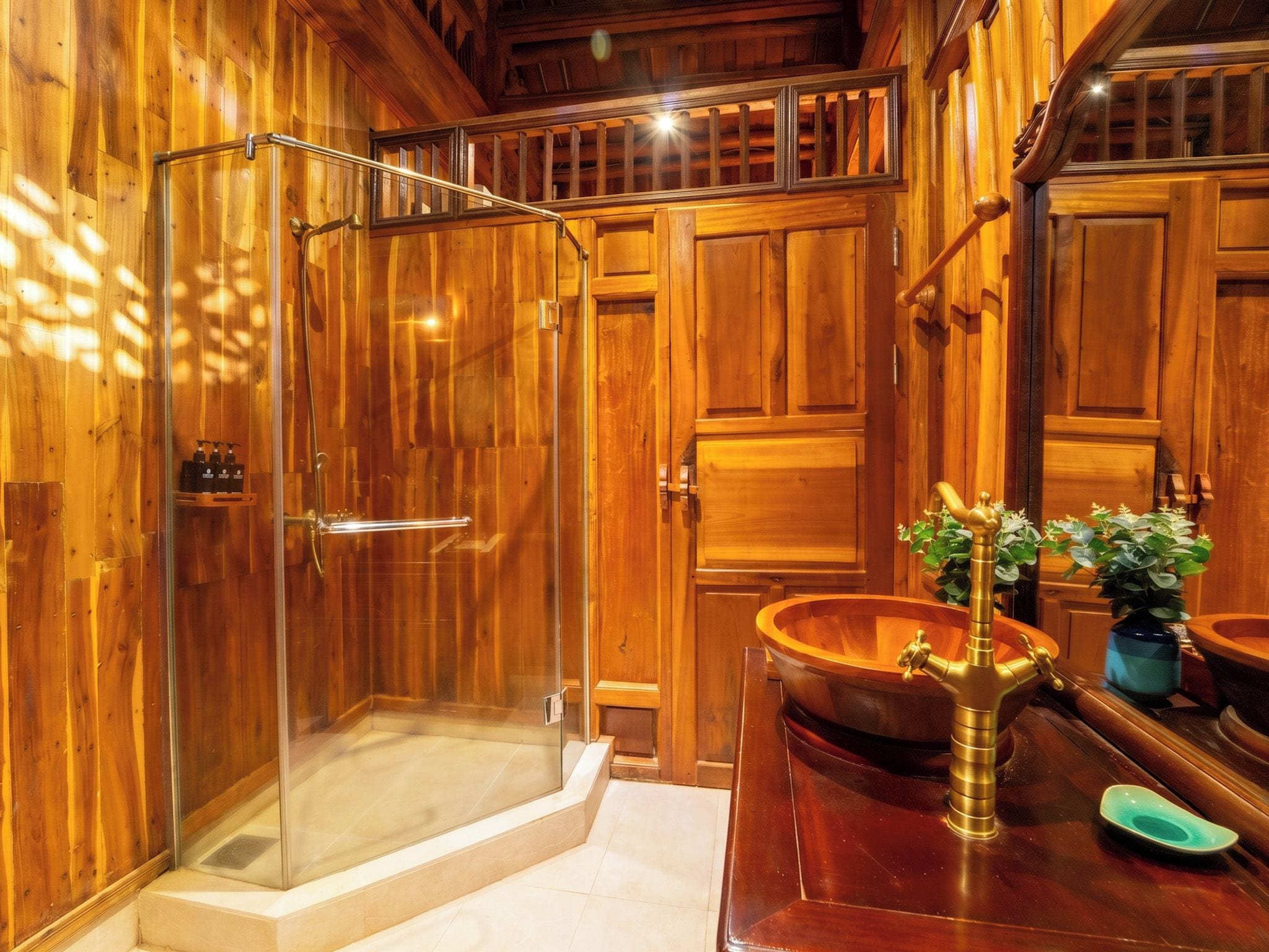 Ein Badezimmer aus Holz mit einer gläsernen Duschkabine, einem Holzboden und einem Waschbecken mit Messingarmatur sowie einer Topfpflanze.