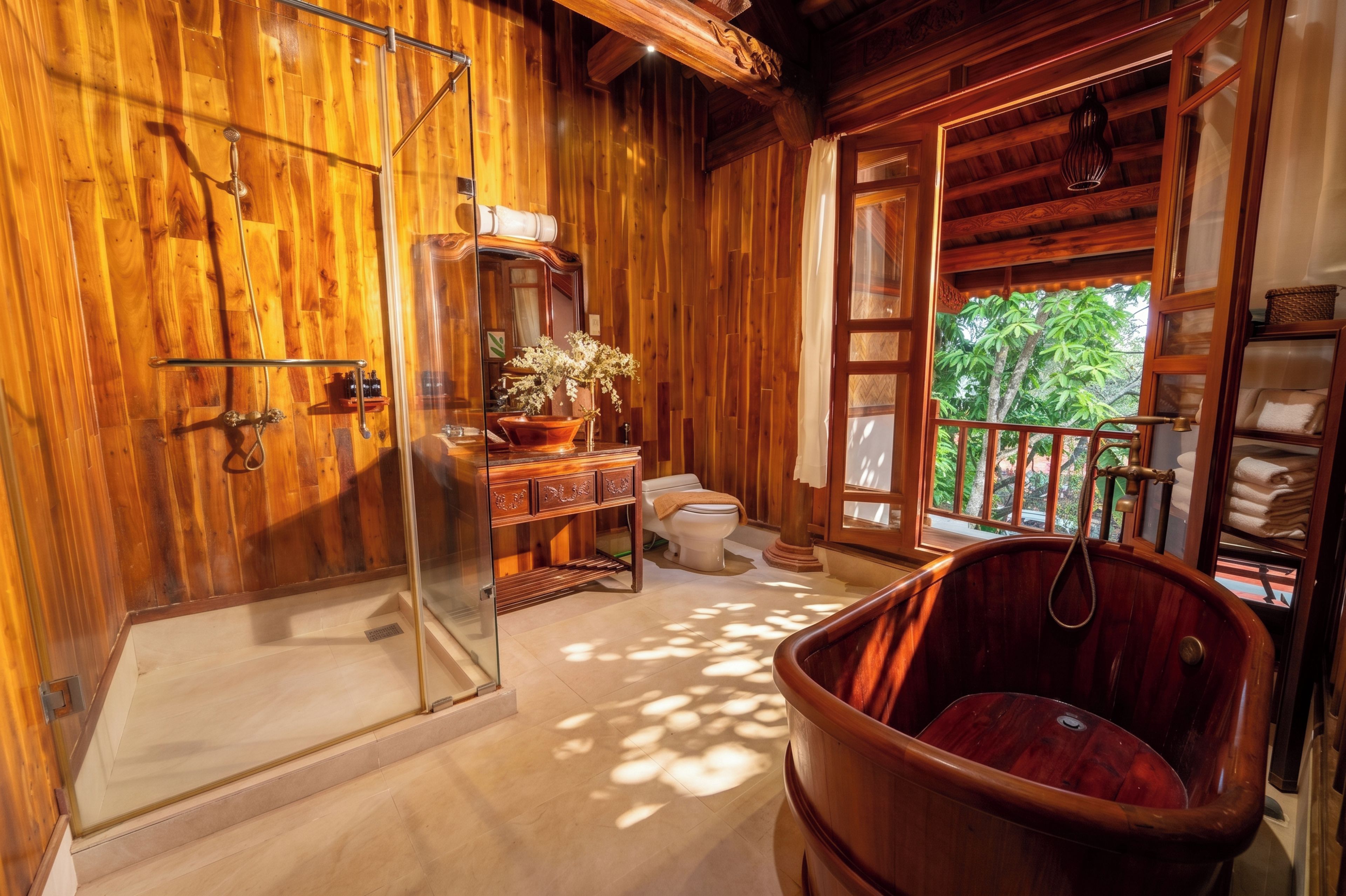 A wooden interior with a glass shower, a wooden bathtub, and a view of greenery outside.