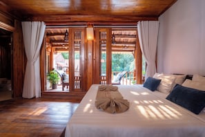 A hotel room with a wooden ceiling, a bed with a towel, and a view of the outside. - Old Town Boutique Resort (Phu Quoc)