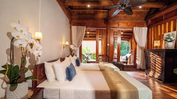 A hotel room with two beds, wooden ceiling, and a view of the outdoors.