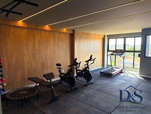 A modern gym with exercise equipment, a bench, and a treadmill. - MARÉ Prime Studio – Private Jacuzzi · Infinity Pool · Ocean & Sunset Views (Tamandaré)