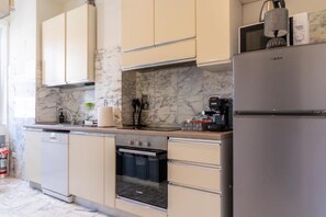 A kitchen with marble backsplash, stainless steel appliances, and beige cabinetry. - SOGNI SUL MARE 5 TERRE-JRE (La Spezia)
