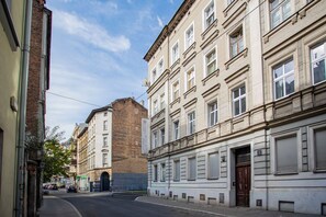 A street view with buildings, including a brick structure and a white building with a sign for 'Cinema Apartments Hostels.' - Klimatyczny Apartament Strzałowa  (Poznań)