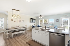 A modern kitchen with a central island, white cabinetry, and a ceiling fan. - A Kure for the Sole 5 bedroom 3 bathroom condo combo. With work from home space (Kure Beach)