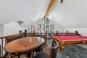 A billiards room with a pool table, chairs, and a view of the outdoors through a window. - Lake & Après Chalet BBQ, Games, Pool Table (South Lake Tahoe)