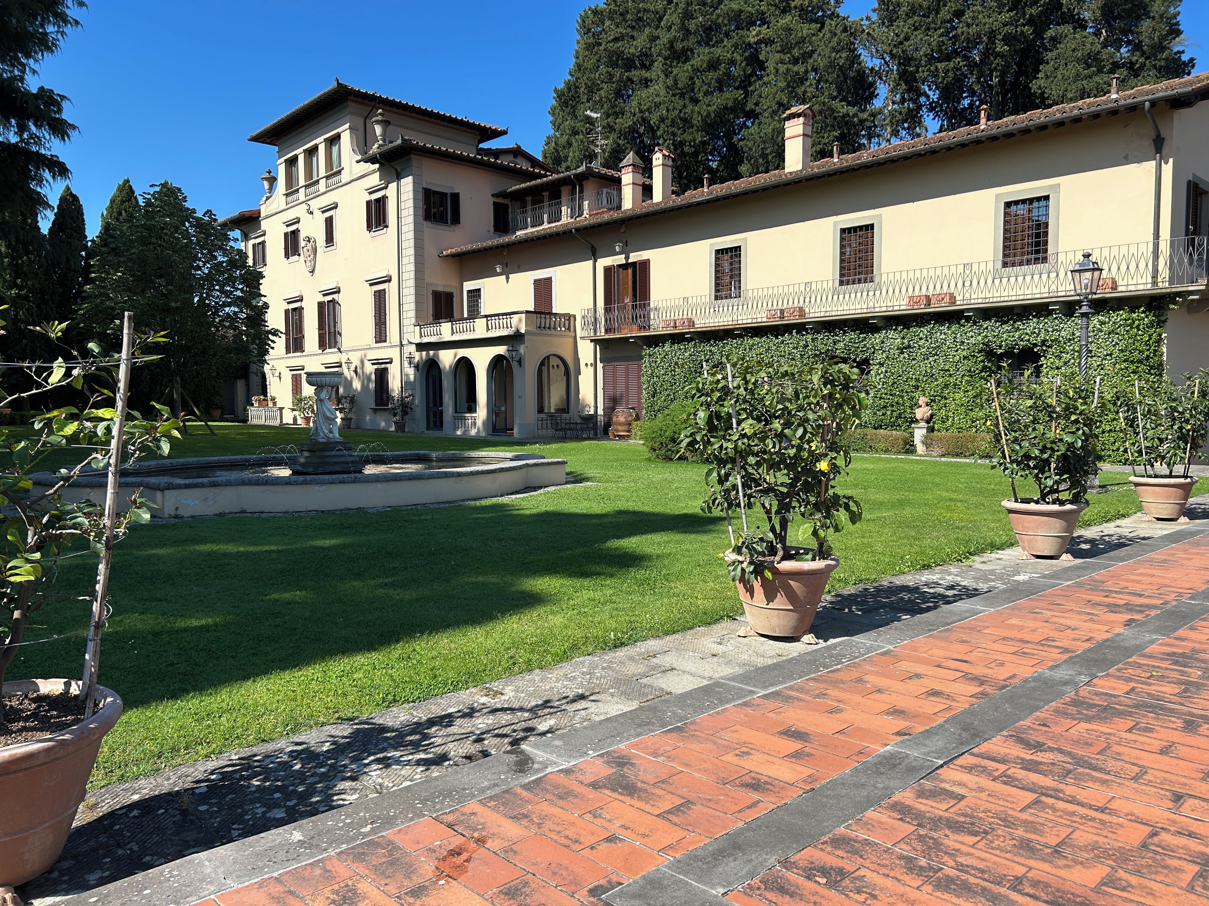 A building with a courtyard, a fountain, and potted plants.