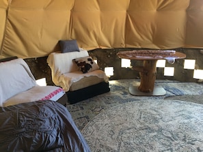 A cozy room with a sofa, a small couch with cushions, a round wooden table, and a patterned rug. - Giant Glamping tepee, sequoia national forest (Bodfish)
