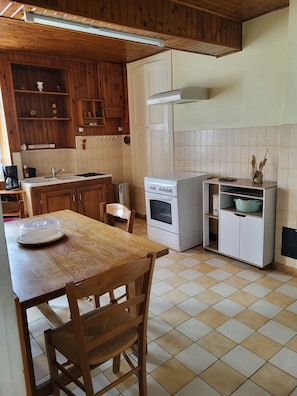 A kitchen with wooden cabinets, a white stove, and a tiled backsplash. - Vacation Home (Château-Chinon (Campagne))