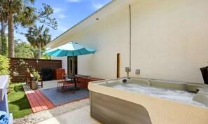 A patio with a hot tub, outdoor furniture, and a wooden fence. - Unique wedge house 1.5 miles from historic district. Amazing for families! (St. Augustine)