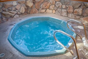 A hot tub with a stone wall background and metal ladder. - Walk to Lifts & Main St | Hot Tub (Breckenridge)