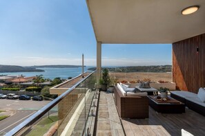 A balcony with a view of the sea, outdoor seating, and a railing. - Mosman Penthouse | Harbour Views + Parking (Mosman)
