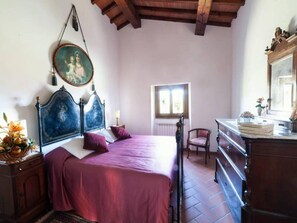 Ein Schlafzimmer mit einem Bett, einem Schminktisch, einem Stuhl und einem Fenster.