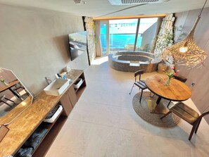 Ein modernes Interieur mit Essbereich, Kamin aus Stein und Meerblick.