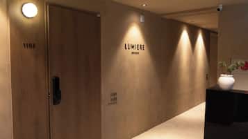 A hallway with two doors labeled 1101 and 1102, a wall with the text 'LUMIERE GWANGAN', and a vase on a table.