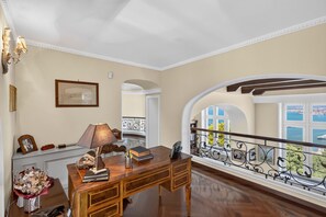 A spacious room with a wooden desk, a lamp, and a framed picture on the wall. - AMORE RENTALS - Villa Imma with Swimming Pool and Sea View (Castellammare di Stabia)